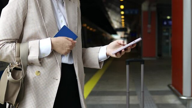Travel woman using smartphone at train station. Young caucasian traveler checking boarding time with mobile phone app in terminal or train station. Business woman businesswoman Tourist on vacation