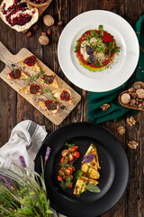 Cheese appetizers: fried halloumi with pesto, roasted cheese with jam, eggplant with mozzarella. Cheese platter on wooden background in rustic style. Composition of hot appetizers on wooden table.