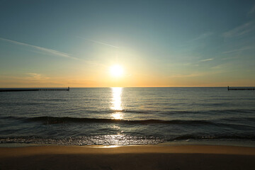 Fototapeta premium Picturesque view of sandy beach and sea at sunset