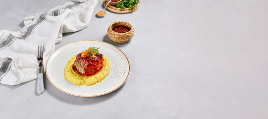 Eastern cuisine - stuffed paprika with mashed potatoes. Stuffed pepper with pure on ceramic plate in contemporary style. Modern concept eastern food menu. Aesthetic composition with main course.