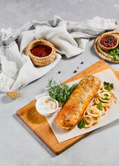 Meat pie with greens and onion on wood plate. Eastern food - beef pie with sesame. Eastern pastry with Minced meat.