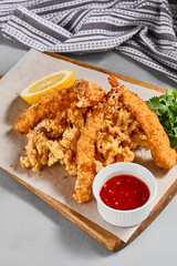 Traditional asian appetizer - crispy shrimps with sauce. Tempura shrimps on wooden board. Prawn tempura in panko breaded with spicy sauce. Pan asian food. Summer menu.