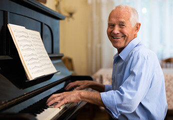 Senior man learning to play piano - Powered by Adobe