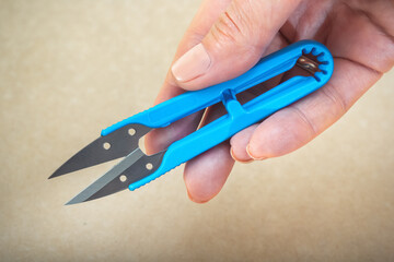 Tailor's snipper for trimming threads in hand. Close-up