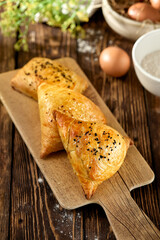 aditional uzbek pastry - samsa with meat. Uzbek pies with meat and puff dough on wooden background in rustic style. Meat samosa with ingredients. East pastry.