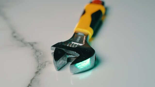 Adjustable wrench for screwing and unscrewing bolts and pipes of different diameters. Plumbing small wrench with adjustable hole diameter. Metal industrial device for repair. Camera rotation