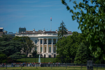 The White House showing the oval office of the president of the United States with tourists looking on a bright summer day.