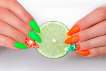 
Beautiful female hands with summer manicure nails, orange and green gel polish