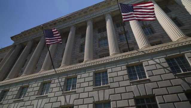 Establishing motion shot of the US Department of Commerce federal building on a beautiful day in Washington, DC.
