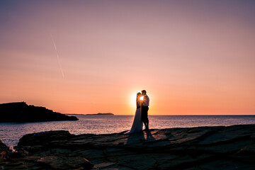 Fototapeta premium silhouette of a couple on their wedding day with a sunset in the background