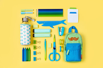School stationery is arranged neatly on yellow background. Pencil case with stationery supplies....