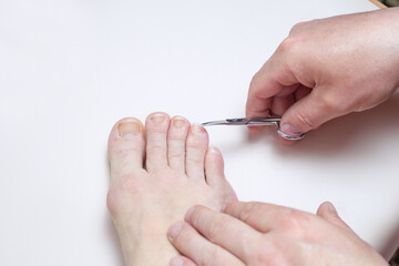 men's hands cut off toenails with scissors