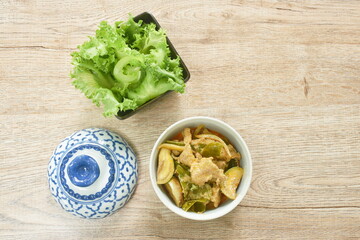 boiled pork with eggplant in coconut milk curry and fresh lettuce in bowl