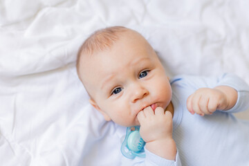 cute little boy in blue body laying on blanket, card, banner, health, space for text