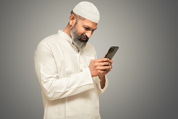 Happy indian pakistani muslim man using smartphone, online shopping, internet banking, using app,...