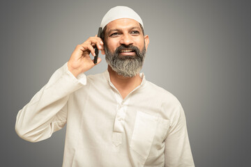 Happy asian indian muslim man talking on mobile phone, isolated.
