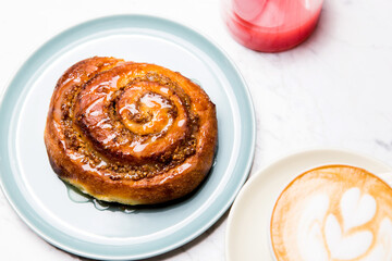 Obraz na płótnie Canvas cinnamon roll breakfast with coffee latte and juice
