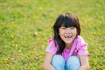happy girl sitting on the grass,  play ground