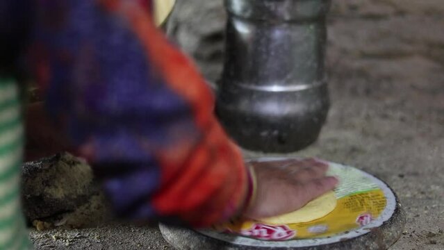 local indian woman making roti or indian flat bread with hand. 
