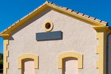 Exterior of a small train station, with a billboard with space for text.