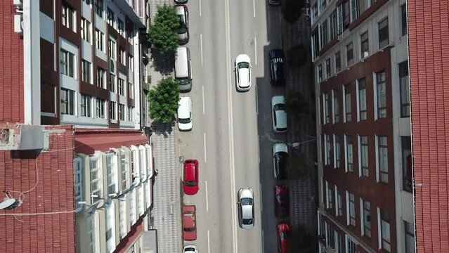 Aerial view of the intersection road, city vehicles and crosswalk between buildings