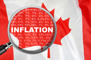 Magnifying glass focused on the word inflation on Canada flag background. Hike interest rate....