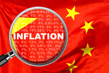 Magnifying glass focused on the word inflation on China flag background. Hike interest rate. Inflation income crisis. Inflation, tax, cash flow and another financial concept in China