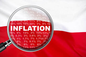 Magnifying glass focused on the word inflation on Poland flag background. Hike interest rate....