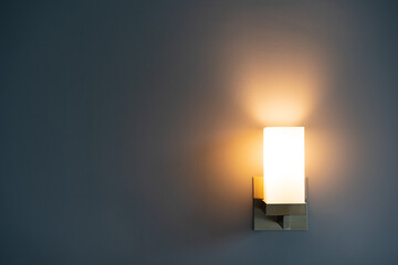 Light on empty wall on hot and cool tones background or modern bedside lamp with warm white for...