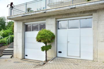 Moderne Beton-Garage mit Automatik-Tor in der Hauszufahrt © Hermann