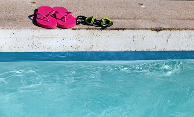 Swimming goggles on the edge of a pool
