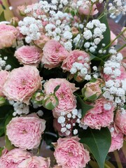 Obraz na płótnie Canvas Pink tea roses and small white gypsophiles.