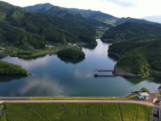 ダム湖の反射した湖面をドローンで空撮した写真