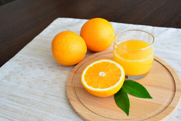 fresh orange juice with orange fruit on wooden tray on kitchen table