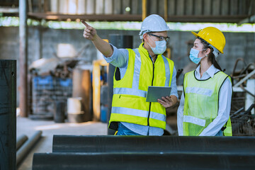 Male and female engineers inspecting newly machined pipes.