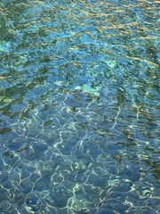 Sea turquoise glittering water clear surface beautiful background in paradise lagoon.