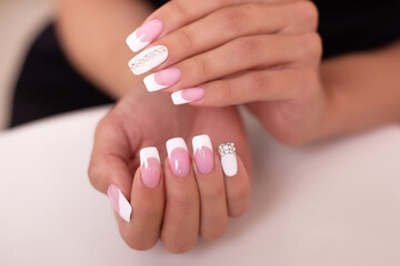
Close up view of beautiful female hands with luxury french manicure nails on white background
