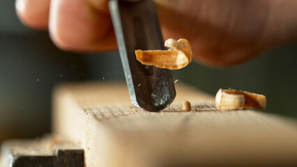 Carpenter planing with chisel, macro shot.