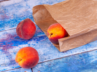 Fresh peaches in a paper bag on the table - 516176597