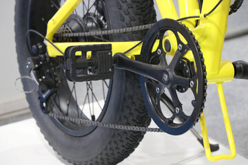 Electric bicycle with pedal option with close up view of chains and wheels. Yellow pedelec bikes