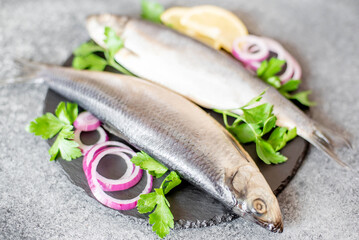 salted herring with red onion and parsley on stone background