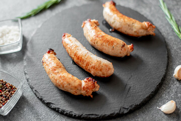 grilled sausages from turkey meat with spices on a stone background 