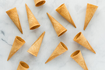 Waffle cones scattered about on a marble background.