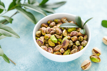 Pistachios. Whole pistachios with green leaves and pistachio nut kernels. Healthy natural vegetarian organic food. Top view, copy space
