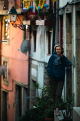 Fototapeta na wymiar A woman stands outside a house in the old town of Porto, Portugal.