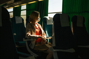 A woman rides in an empty intercity bus.