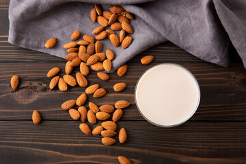 Almond and almond milk on wooden table - obrazy, fototapety, plakaty