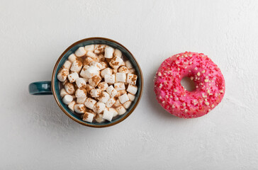Cocoa drink on texture background. Hot chocolate with small marshmallows and sweet donuts. Winter warming drink concept. Copy space. Space for text