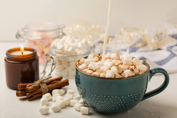 Cup of tasty cocoa drink and marshmallows in blue cup.Spices and marshmallows for winter drinks on white texture table.Winter hot drink.Hot chocolate with marshmallow and spices.Copy space.