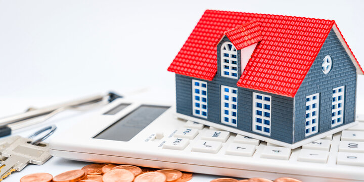House model, calculator, coins and keys on white background - house buying concept image